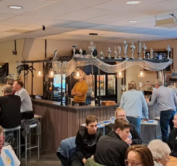 Leden samen aan de bar in de kantine na het spelen